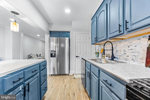 2134 Firethorn Rd, Middle River, MD 21220 - kitchen featuring appliances with stainless steel finishes, blue cabinets, light countertops, tasteful backsplash, and light wood-style floors