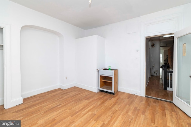 2308 N Park Ave, Philadelphia, PA 19132 - empty room featuring light wood finished floors, baseboards, and arched walkways