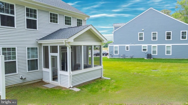 35031 Dundee St Unit 6, Frankford, DE 19945 - back of house with a sunroom, a lawn, central AC, and a shingled roof