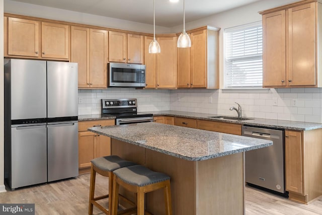 35031 Dundee St Unit 6, Frankford, DE 19945 - kitchen with appliances with stainless steel finishes, a sink, light wood-style flooring, a breakfast bar, and decorative backsplash