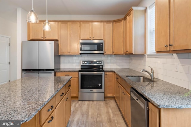 35031 Dundee St Unit 6, Frankford, DE 19945 - kitchen with stainless steel appliances, a sink, light wood finished floors, dark stone counters, and decorative backsplash