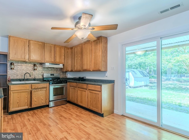 18552 Three Notch Rd, Lexington Park, MD 20653 - kitchen featuring stainless steel range with gas cooktop, a sink, under cabinet range hood, light wood-type flooring, and dark countertops