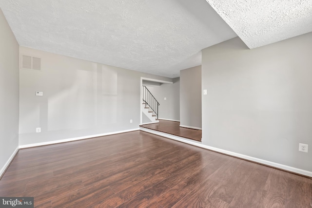 10779 Primrose Ct, Manassas, VA 20109 - empty room featuring a textured ceiling, wood finished floors, stairway, and baseboards