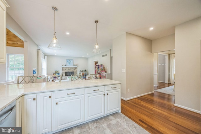31 Bramley Rd, Moorestown, NJ 08057 - kitchen featuring a fireplace, light stone counters, open floor plan, decorative light fixtures, and white cabinetry