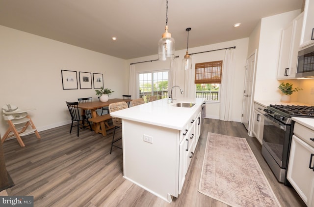 159 Nathan Dr, Cinnaminson, NJ 08077 - kitchen featuring gas range oven, wood finished floors, white cabinetry, an island with sink, and stainless steel microwave
