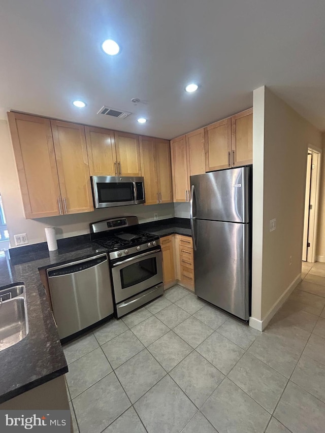820 N Pollard St Unit 413, Arlington, VA 22203 - kitchen featuring appliances with stainless steel finishes, light tile patterned floors, dark stone countertops, recessed lighting, and a sink