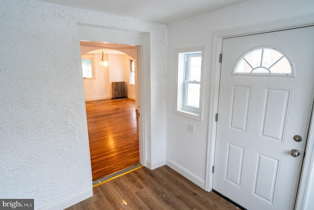 6982 Clinton Rd, Upper Darby, PA 19082 - entryway featuring radiator, wood finished floors, baseboards, arched walkways, and a textured wall