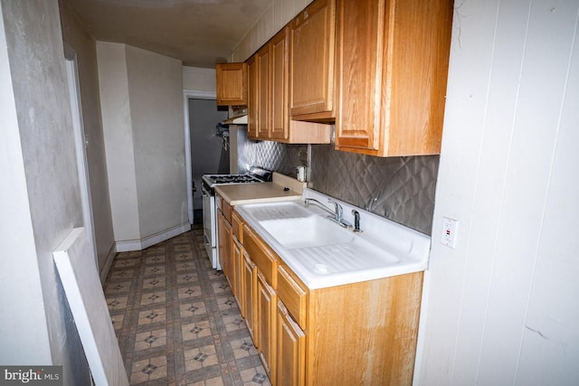6982 Clinton Rd, Upper Darby, PA 19082 - kitchen featuring gas range, tile patterned floors, light countertops, a sink, and under cabinet range hood
