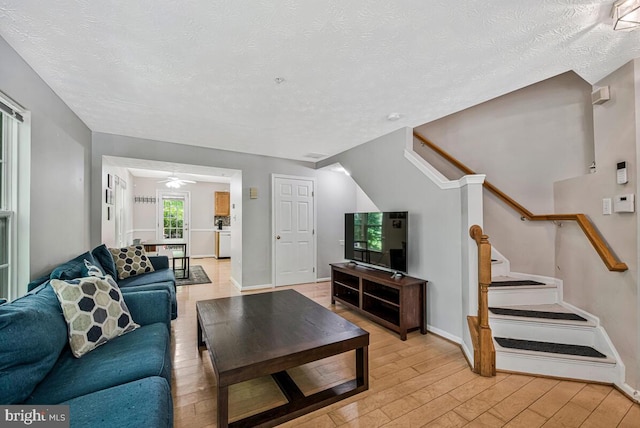 3218 Water Lily Ct, Laurel, MD 20724 - living area with light wood-style floors, stairs, a textured ceiling, ceiling fan, and baseboards