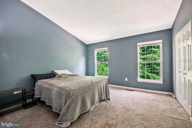 3218 Water Lily Ct, Laurel, MD 20724 - carpeted bedroom featuring a textured ceiling, a closet, baseboards, and vaulted ceiling