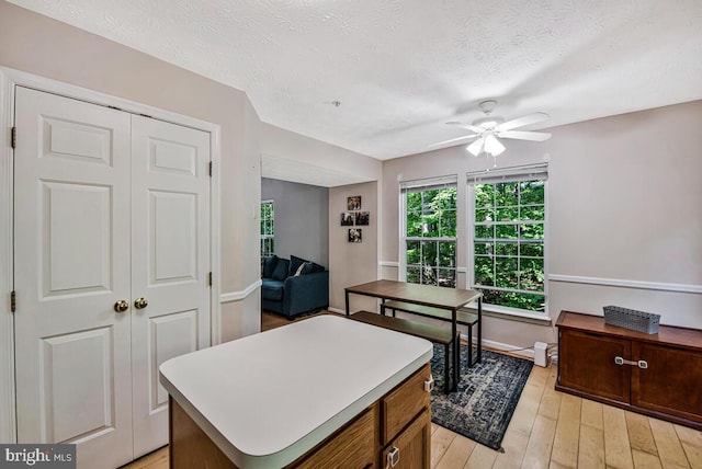 3218 Water Lily Ct, Laurel, MD 20724 - kitchen featuring a ceiling fan, light wood-type flooring, a textured ceiling, light countertops, and a center island