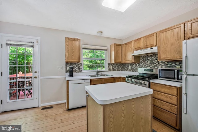 3218 Water Lily Ct, Laurel, MD 20724 - kitchen with stainless steel appliances, a sink, under cabinet range hood, light wood-type flooring, and decorative backsplash