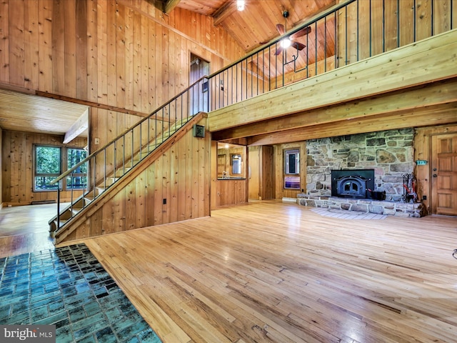 2511 W Norwegian St, Pottsville, PA 17901 - unfurnished living room with a towering ceiling, hardwood / wood-style flooring, stairway, wood walls, and wooden ceiling with exposed beams