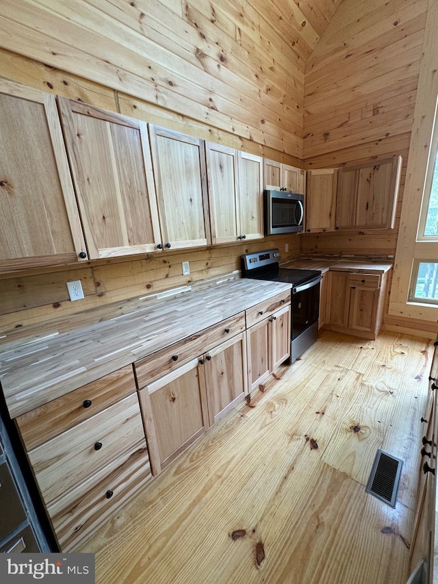 68 Taylor Ln, Mc Henry, MD 21541 - kitchen with stainless steel microwave, range with electric stovetop, vaulted ceiling, light wood finished floors, and light brown cabinets