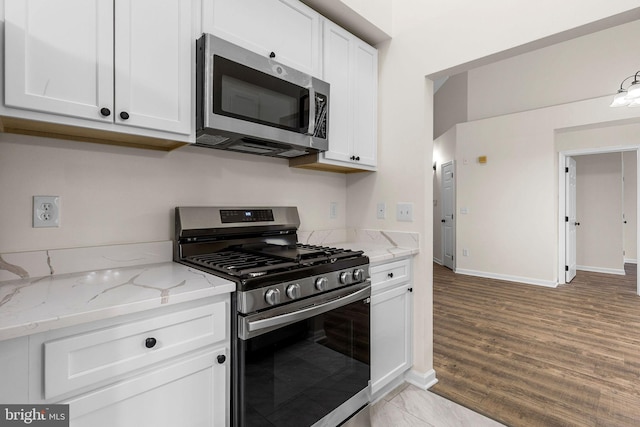 5948 Founders Hill Dr Unit 301, Alexandria, VA 22310 - kitchen with stainless steel appliances, white cabinetry, light stone counters, and baseboards