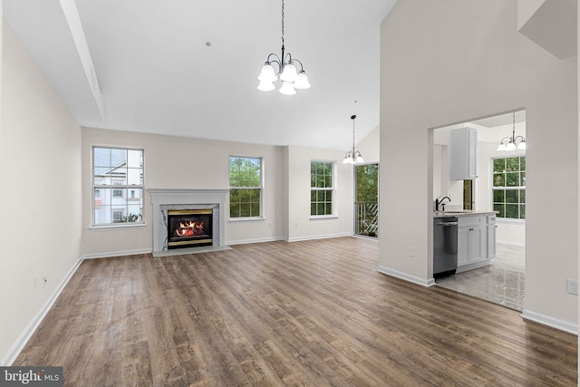5948 Founders Hill Dr Unit 301, Alexandria, VA 22310 - unfurnished living room with a chandelier, wood finished floors, baseboards, healthy amount of natural light, and a high ceiling