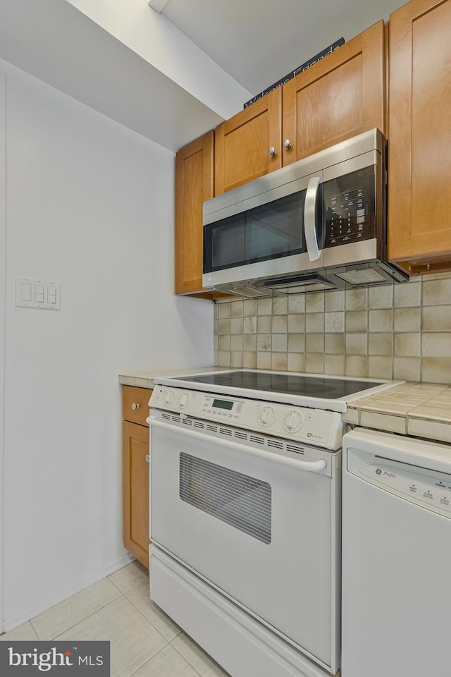 11174 Glade Dr, Reston, VA 20191 - kitchen featuring white appliances, decorative backsplash, light tile patterned floors, and tile countertops