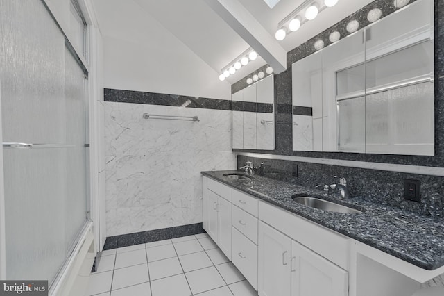 11174 Glade Dr, Reston, VA 20191 - bathroom featuring double vanity, tile patterned flooring, tile walls, and vaulted ceiling