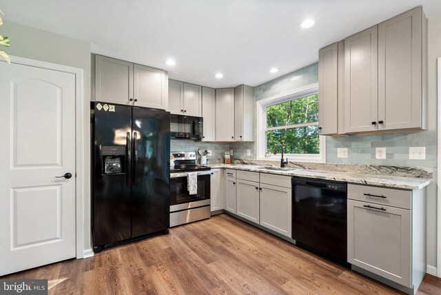 1820 Gooney Manor Loop, Bentonville, VA 22610 - kitchen with black appliances, gray cabinetry, tasteful backsplash, light stone countertops, and wood finished floors