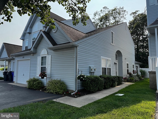 132 Seabright Way Unit D5, Rehoboth Beach, DE 19971 - view of property exterior with a shingled roof, a lawn, an attached garage, and asphalt driveway