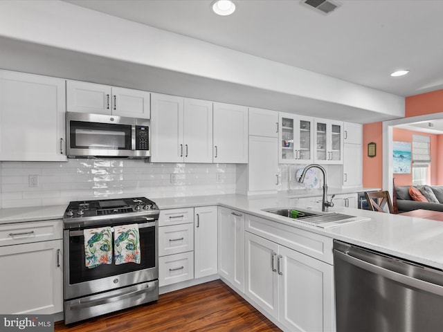 132 Seabright Way Unit D5, Rehoboth Beach, DE 19971 - kitchen featuring appliances with stainless steel finishes, a sink, white cabinets, light countertops, and glass insert cabinets