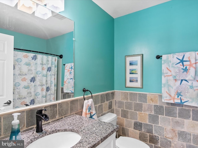 132 Seabright Way Unit D5, Rehoboth Beach, DE 19971 - full bathroom featuring vanity, toilet, tile walls, a shower with shower curtain, and a wainscoted wall