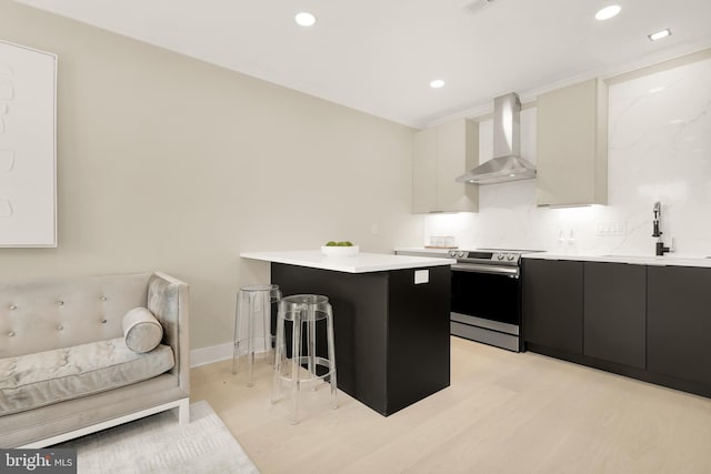 2305 Nicholson St SE Unit 305, Washington, DC 20020 - kitchen with wall chimney exhaust hood, electric range, a sink, a kitchen breakfast bar, and dark cabinetry