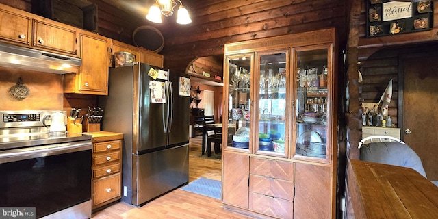 453 Mountain Heights Rd, Front Royal, VA 22630 - kitchen featuring appliances with stainless steel finishes, under cabinet range hood, light wood-style flooring, brown cabinetry, and a chandelier