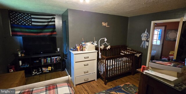 453 Mountain Heights Rd, Front Royal, VA 22630 - bedroom with wood finished floors, a textured ceiling, and a nursery area