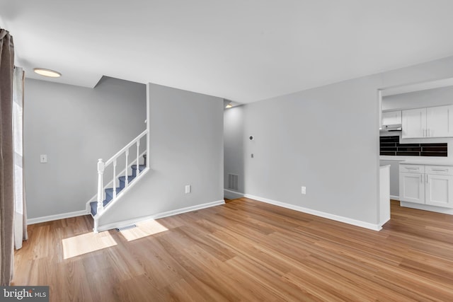 31 Ewing Dr Unit C, Reisterstown, MD 21136 - unfurnished living room featuring light wood finished floors and stairs