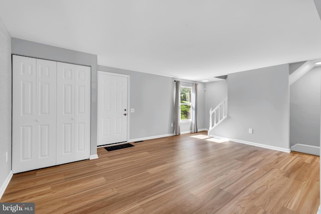 31 Ewing Dr Unit C, Reisterstown, MD 21136 - unfurnished living room with light wood-style floors and stairway