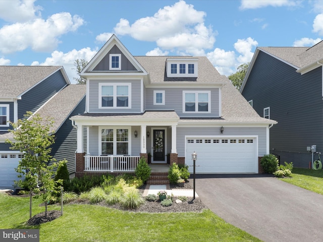 18090 Marsh Pine Rd, Dumfries, VA 22026 - craftsman inspired home with a porch, asphalt driveway, roof with shingles, brick siding, and a front lawn