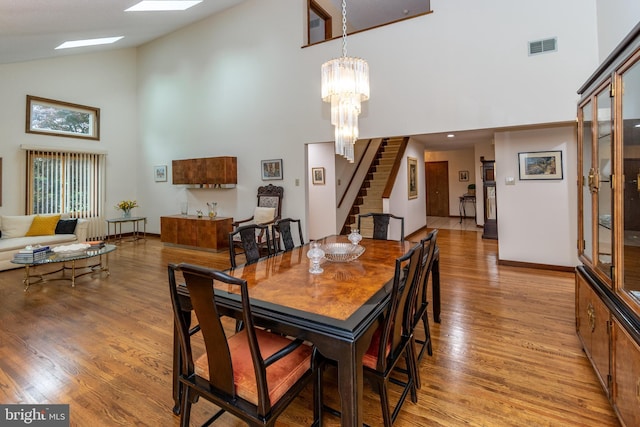 27 Arnold Dr, Princeton Junction, NJ 08550 - dining room featuring high vaulted ceiling, stairs, light wood-style floors, and a chandelier