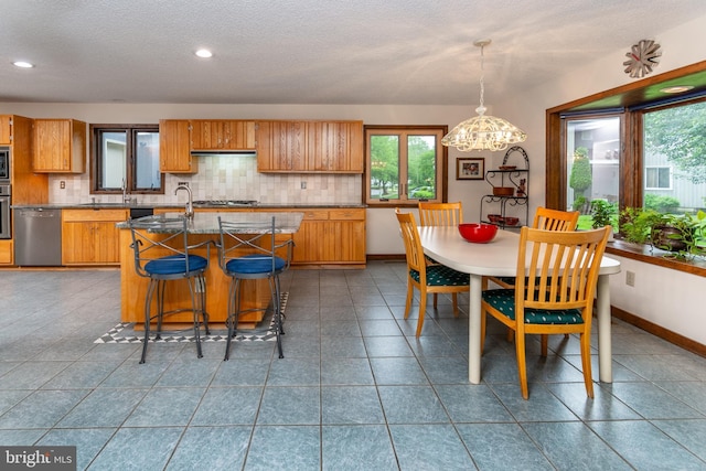 27 Arnold Dr, Princeton Junction, NJ 08550 - kitchen with stainless steel appliances, decorative backsplash, a chandelier, brown cabinets, and a textured ceiling