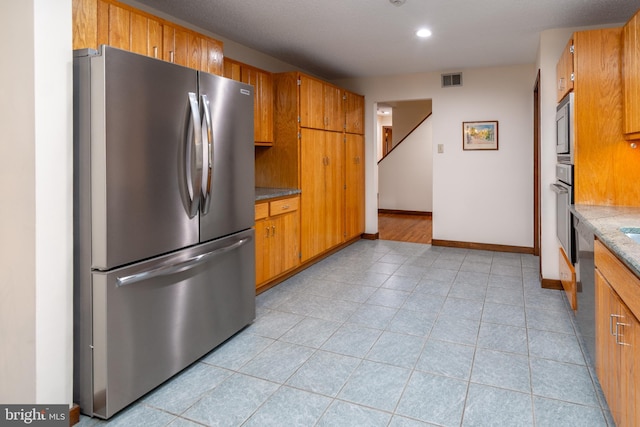 27 Arnold Dr, Princeton Junction, NJ 08550 - kitchen with stainless steel appliances, brown cabinetry, light tile patterned flooring, and recessed lighting