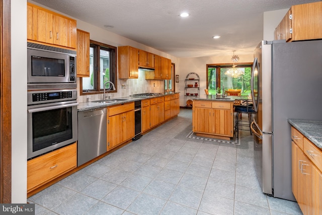 27 Arnold Dr, Princeton Junction, NJ 08550 - kitchen with appliances with stainless steel finishes, decorative backsplash, recessed lighting, a center island, and brown cabinetry