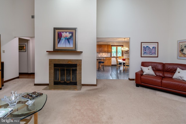 27 Arnold Dr, Princeton Junction, NJ 08550 - carpeted living room featuring a high ceiling, a chandelier, and a fireplace with flush hearth