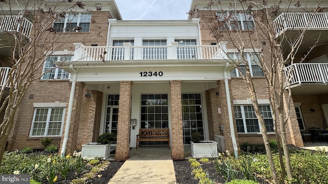 12340 Rosslare Ridge Rd Unit 204, Lutherville Timonium, MD 21093 - view of exterior entry featuring brick siding, a balcony, and covered porch