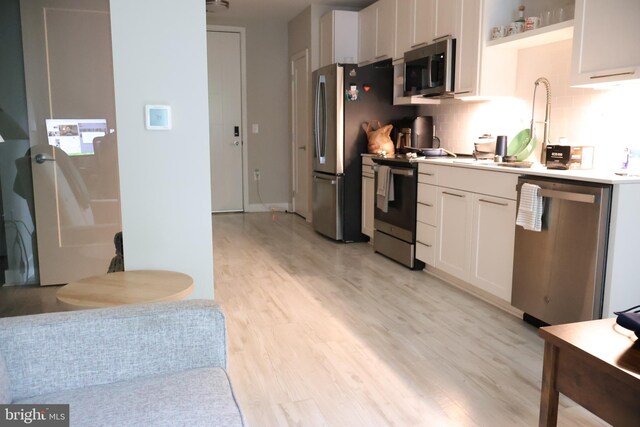12340 Rosslare Ridge Rd Unit 204, Lutherville Timonium, MD 21093 - kitchen featuring stainless steel appliances, light wood-style floors, white cabinetry, open shelves, and tasteful backsplash