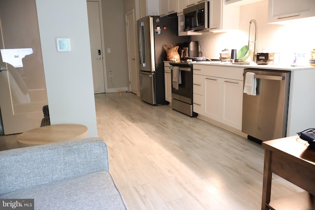 12340 Rosslare Ridge Rd Unit 204, Lutherville Timonium, MD 21093 - kitchen with stainless steel appliances, light wood-style floors, white cabinetry, a sink, and light countertops