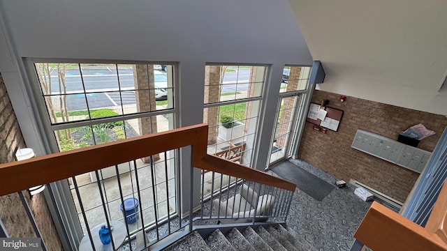 12340 Rosslare Ridge Rd Unit 204, Lutherville Timonium, MD 21093 - staircase with brick wall, healthy amount of natural light, high vaulted ceiling, and carpet flooring