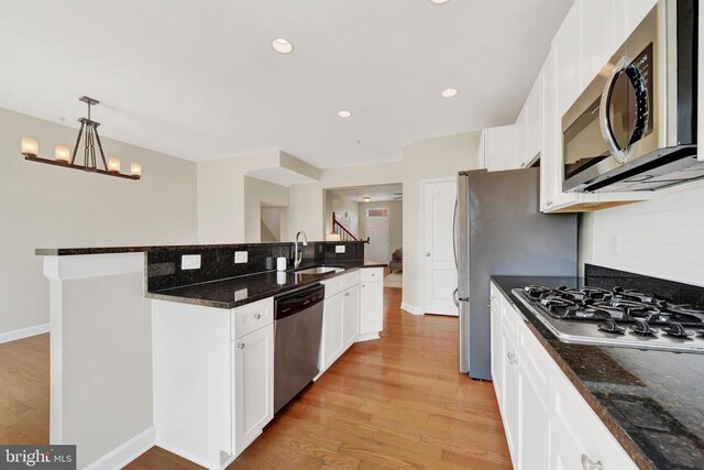 1501 Stack St, Baltimore, MD 21230 - kitchen with stainless steel appliances, light wood-style floors, white cabinetry, backsplash, and recessed lighting