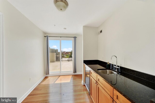 1501 Stack St, Baltimore, MD 21230 - kitchen with light wood-style flooring, dark stone counters, and brown cabinets