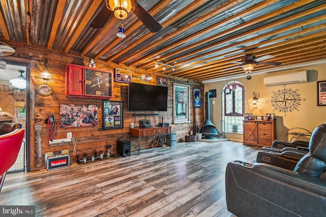 947 Martin Rd, Baltimore, MD 21221 - living room with an AC wall unit, ceiling fan, a wood stove, wood finished floors, and wood walls