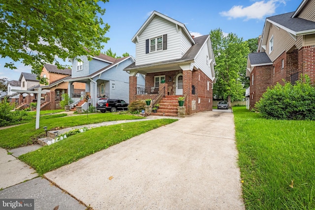 2707 Kildaire Dr, Baltimore, MD 21234 - view of front of house featuring concrete driveway, brick siding, a porch, a front lawn, and a residential view