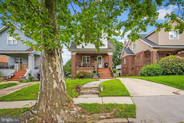 2707 Kildaire Dr, Baltimore, MD 21234 - view of front of house featuring a porch, driveway, brick siding, stairway, and a front yard