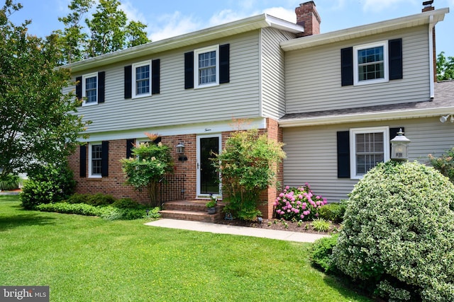 12 Hatsawap Rd, Cambridge, MD 21613 - colonial home with a front yard, a chimney, and brick siding