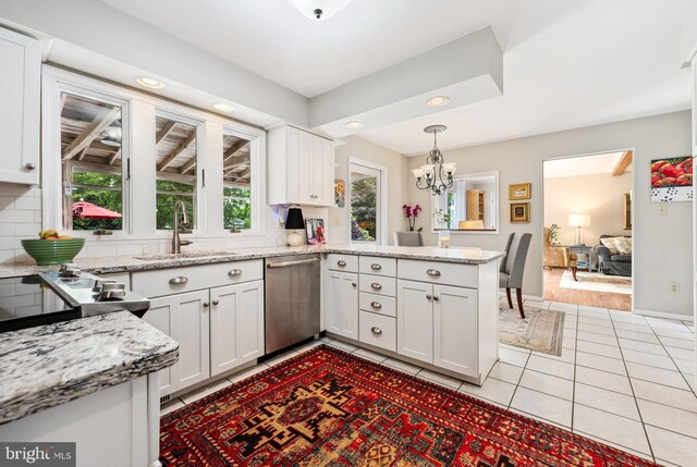 12 Hatsawap Rd, Cambridge, MD 21613 - kitchen with stainless steel appliances, a sink, a peninsula, white cabinets, and a chandelier