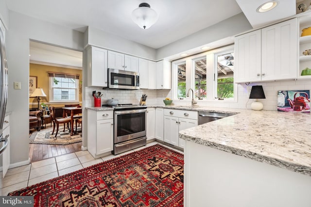 12 Hatsawap Rd, Cambridge, MD 21613 - kitchen with stainless steel appliances, open shelves, white cabinets, backsplash, and recessed lighting