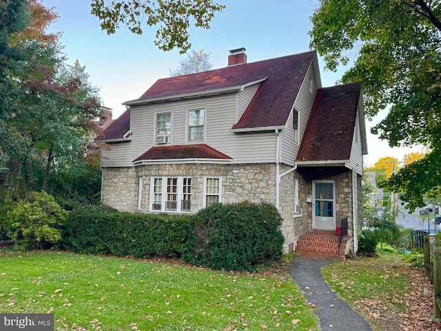 348 E Foster Ave, State College, PA 16801 - view of front of home with stone siding, a chimney, a front lawn, and a shingled roof